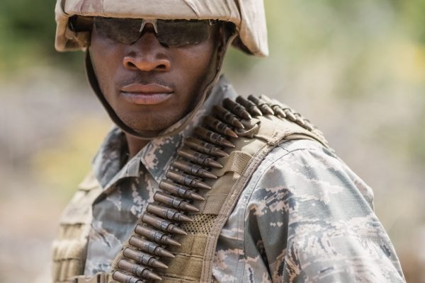 Military soldier standing with ammunition in boot camp